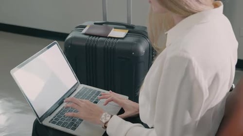 Passenger traveler woman in airport gate working laptop while waiting boarding air before vacation