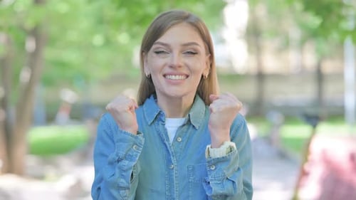 Young Woman Celebrating Success Outdoor in Park