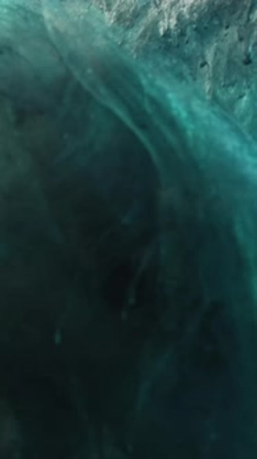 Turquoise and Black Paint Swirling Slowly