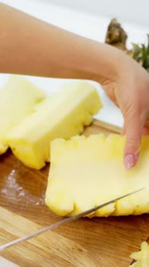 Hands Cut Fresh Pineapple into Pieces