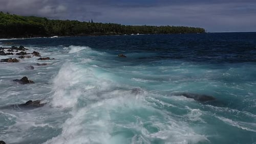 Des vagues turquoises ondulantes le long de la côte rocheuse d'Hawaï