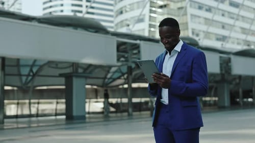 Portrait of Happy African American Businessman Surfs Internet on Digital Tablet in City
