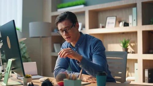 Young Adult Male Teleconferencing at Home Workplace