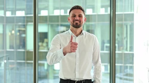 Businessman Gives Thumbs Up in Modern Office Showing Approval and Positive Feedback