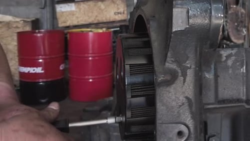 Man Assembling Machine with Wrench in Workshop