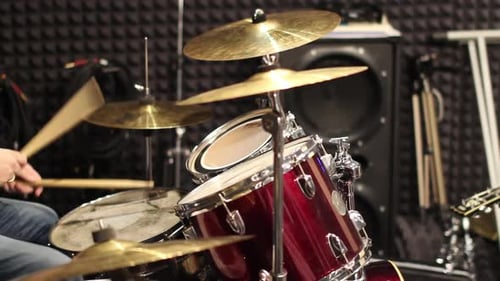A musician drummer plays a drum kit in a recording studio. Drumming in the rehearsal base