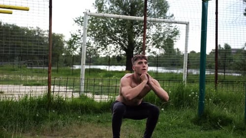 Male Shirtless Athlete Doing Squats at Sports Ground Young Sportsman Working at Summer Nature Strong