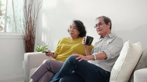 Elderly Couple Relaxing at Home with TV