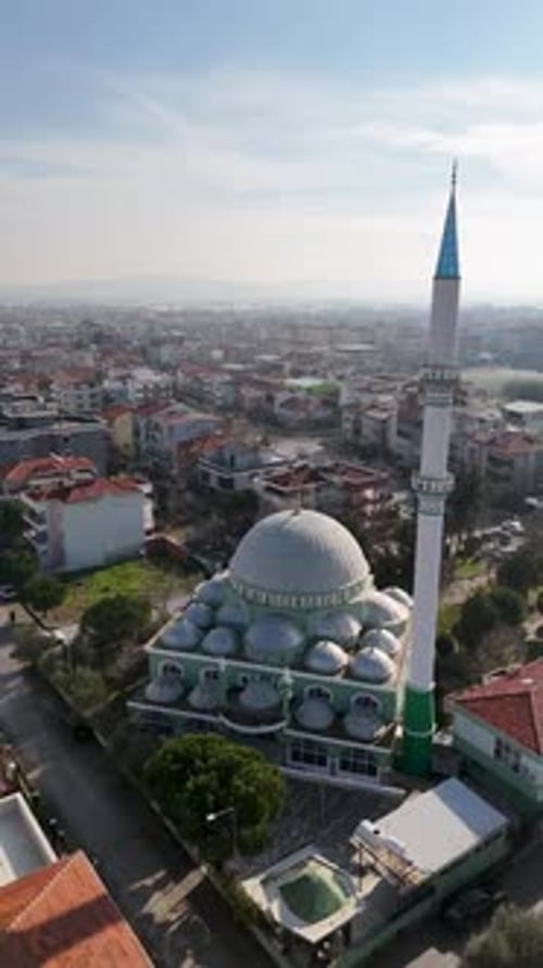 Vue aérienne verticale de la mosquée et des champs agricoles avec la ville en arrière-plan