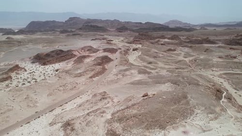 Aerial view over a car on a desert road in the Timna, Israel - tilt, drone shot