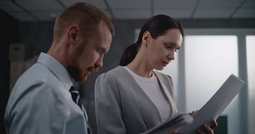 Portrait of Two Financial Specialists Watching Documents Discussing Project Ideas