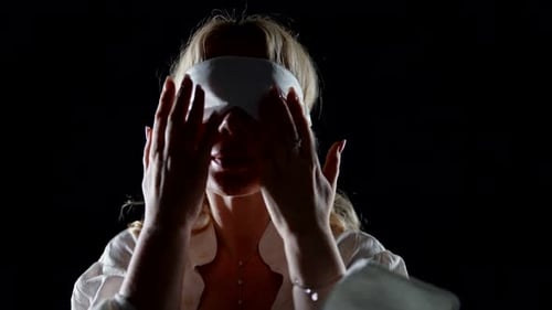 Mulher vendada com máscara de dormir nos olhos Retrato médio na escuridão
