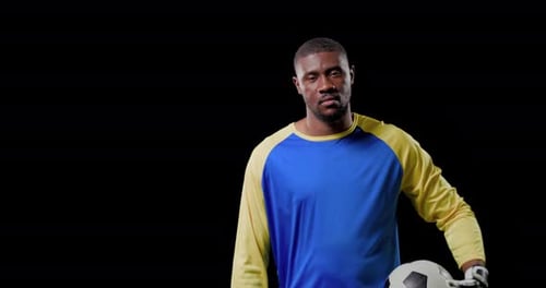 Goleiro masculino se estendendo, puxando a bola para dentro, relaxando a postura enquanto aperta a câmera para esportes