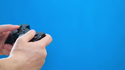 Hands Play Video Game with Controller on Blue Background
