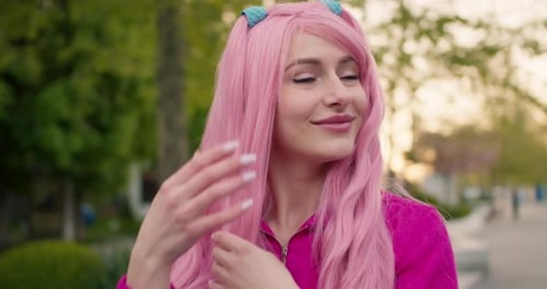 Smiling Woman with Pink Hair Posing in Park