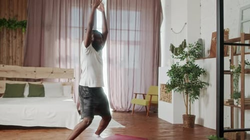 Man Exercising on Yoga Mat in Bedroom