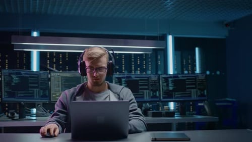 Man Coding with Laptop in Data Center