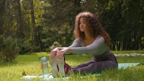 Woman Stretching on Yoga Mat in Green Park