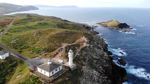 Cliffside Lighthouse Bathed In Morning Glow Vantage Of Towering Lighthouse Overlooking Stormy Ocean
