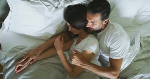 Loving Couple Cuddling in Bed Together Comfortably