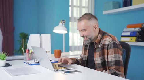 Man Smiling, Using Laptop at Desk