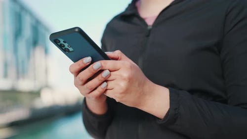 Woman, phone and hands typing in city for outdoor communication, networking or online browsing
