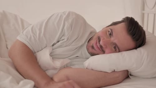 Man Smiling in Bed Lying Sideways Relaxing