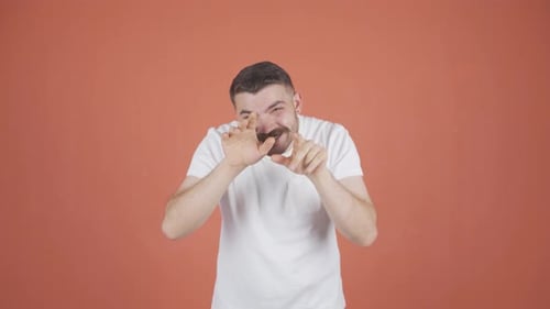 Man Posing and Making Faces Against Orange Backdrop
