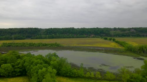 Video of Drone/Aerial Flyover of a field and lake near a river 1