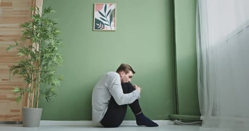 Anxious Man Embracing Knee and Shaking