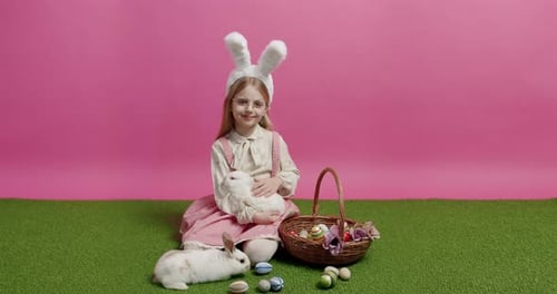 Girl with Bunny Ears Holding Rabbit on Grass