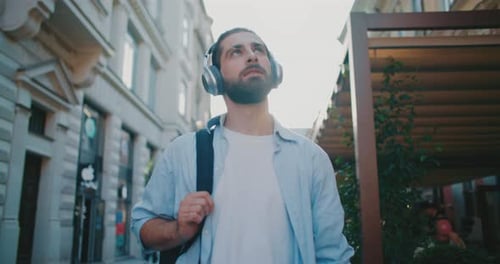 Young Man Walking in City with Headphones