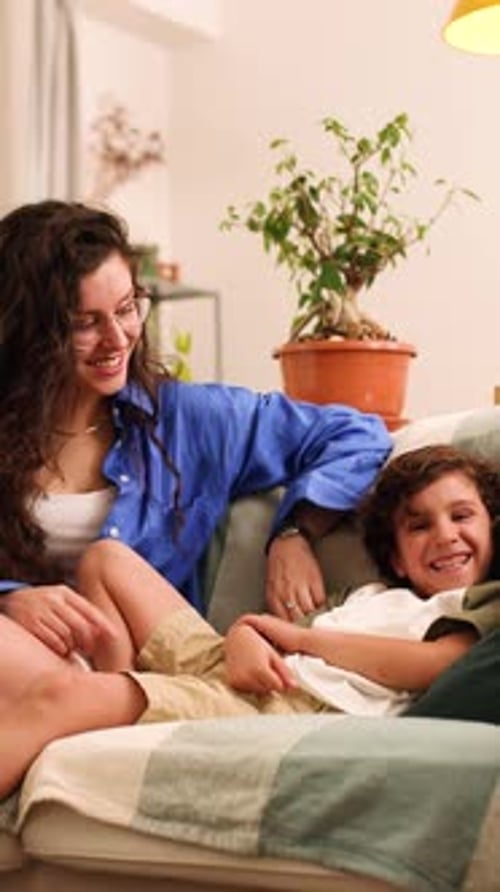 Mother and Child Relaxing on Sofa Indoors