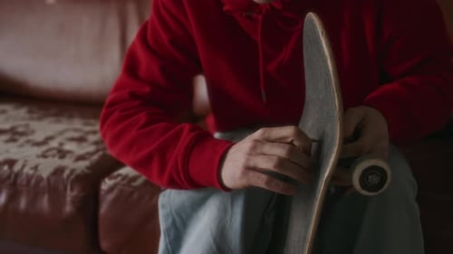 Man Works on Skateboard Indoors