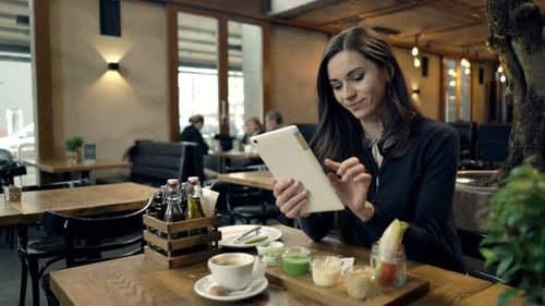 Portrait of Happy, Young Woman with Tablet Computer Sitting in Cafe Adult