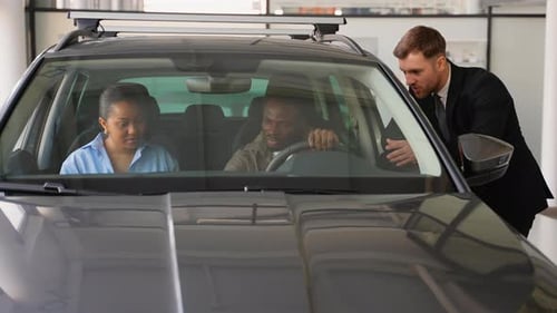 Sales Person Talking to Couple Inside New Car