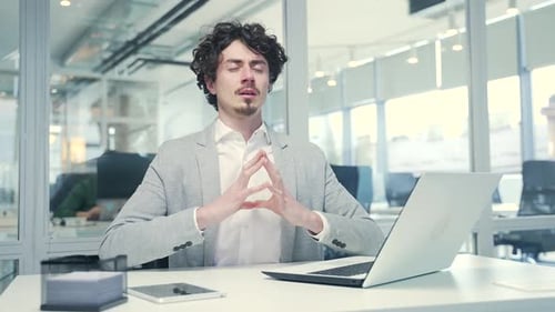 Man Meditating at Desk in Corporate Office