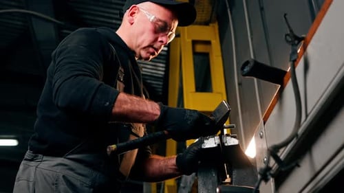 At a Service Station Car Mechanic's Hands Work with a Hammer on a Car Disk