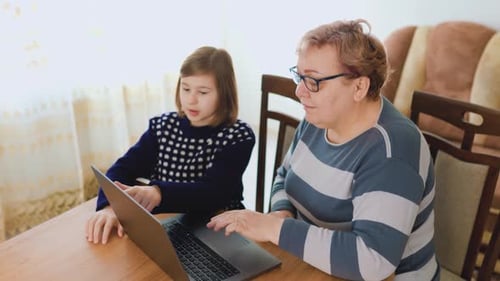 Learning Together A Kid Helping a Senior with Technology