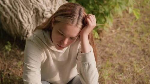 Girl Rests Head in Hand Outdoors