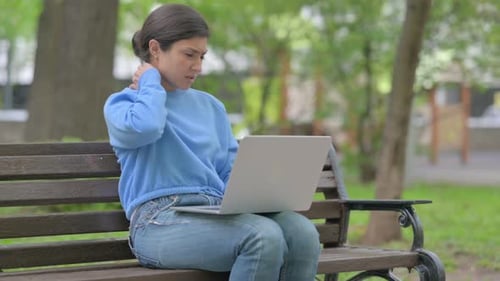 Woman Uses Laptop on Park Bench