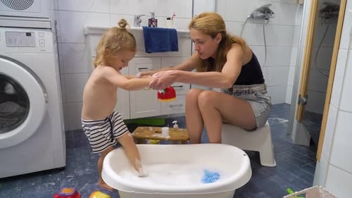 Mother and Child Playing in Bathtub Together