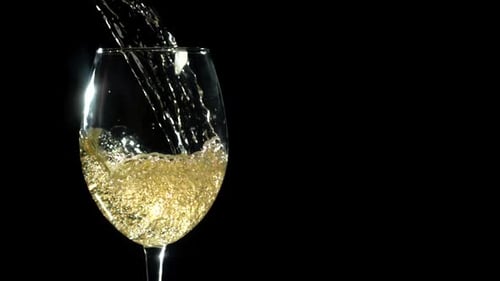 Pouring White Wine into Glass on Black Background