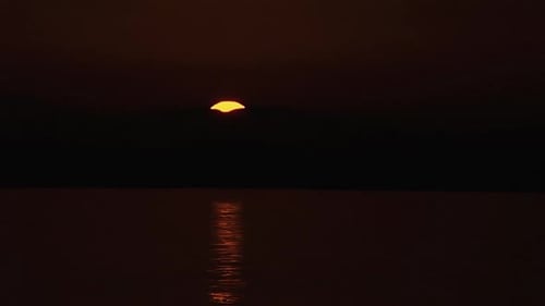 Sun rises behind mountains and sea in Greece
