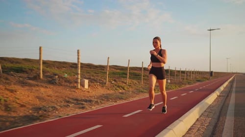 Woman Runs on Red Path Exercising Outdoors