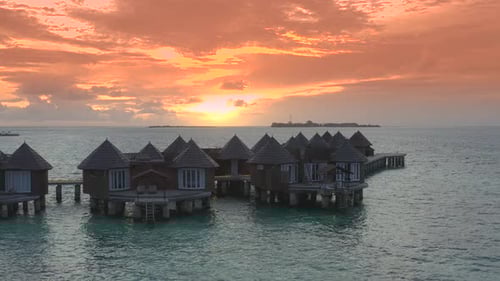 Overwater Villas at the Time Amazing Sunset in Tropical Sea with Coral Reef