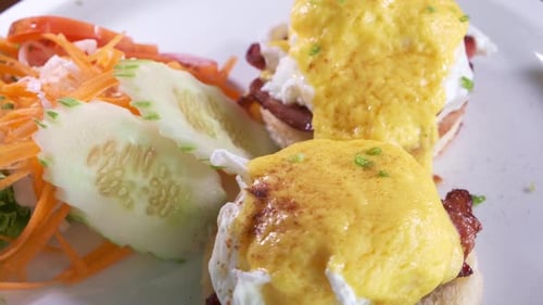 eggs Benedict Breakfast with Poached Eggs and Bacon on Muffins. Freshly Cooked Rotating with Close u