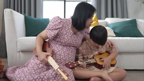 Woman and Child Playing Ukuleles Together at Home
