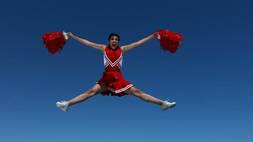 Cheerleader leaps into air, performing splits