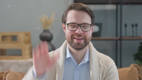 Man Talking and Waving on a Video Call